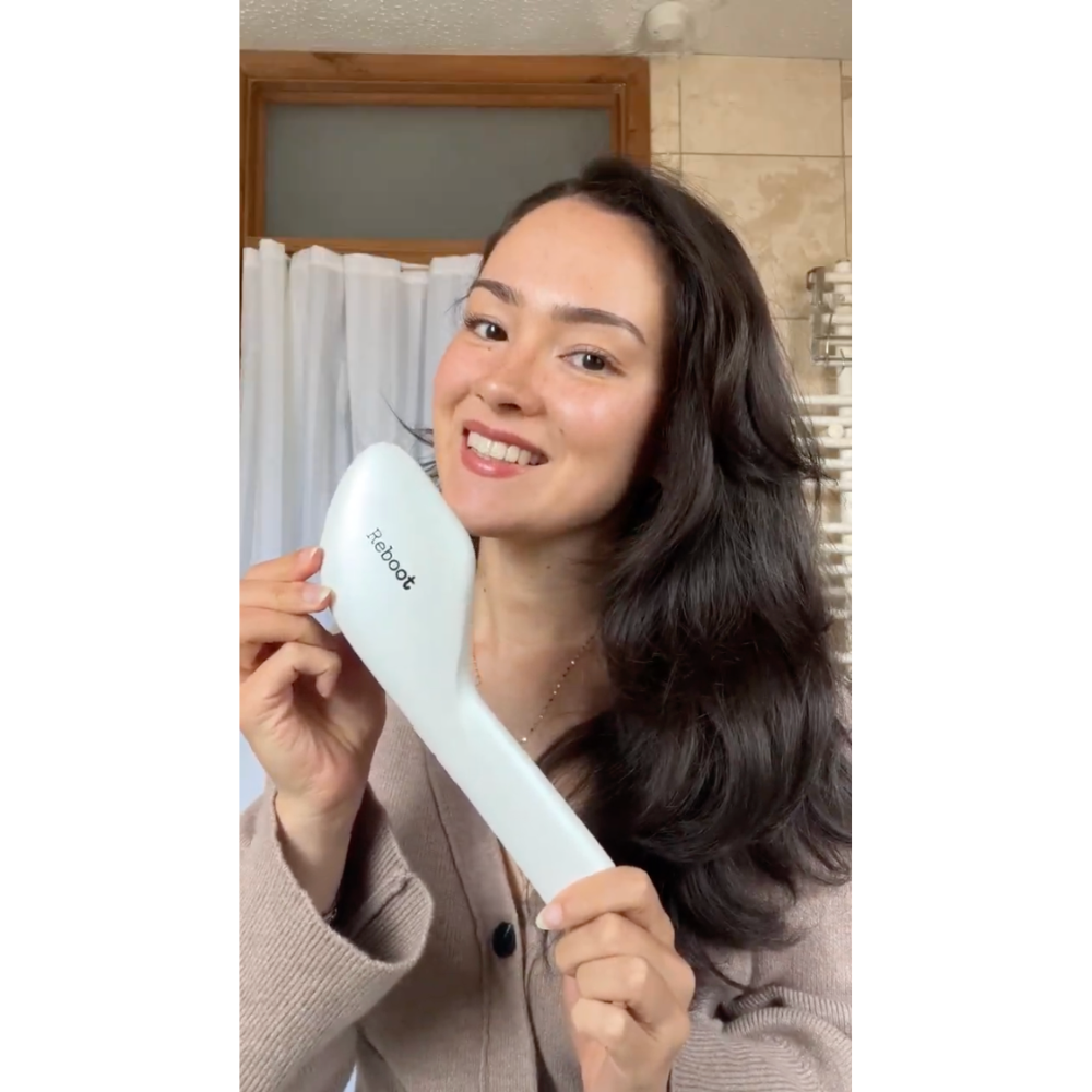 Woman holding Reboot Scalp Rejuvenator LED Comb 