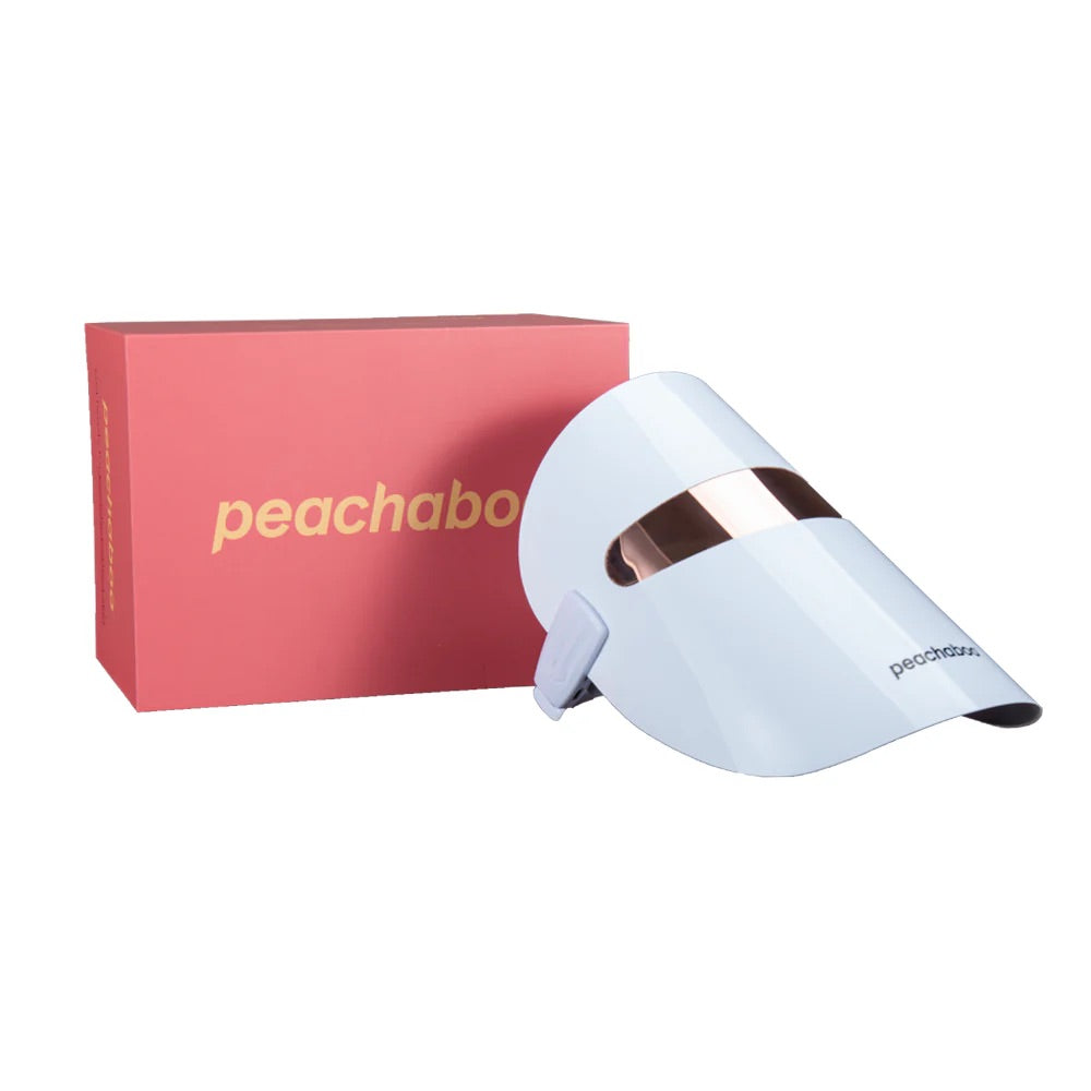 Peachaboo Glo LED Light Therapy Mask next to it's packaging on a white background