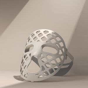 A white mesh-designed mask, the Peachaboo Glo Aurora, featuring LED light therapy technology for skin rejuvenation.