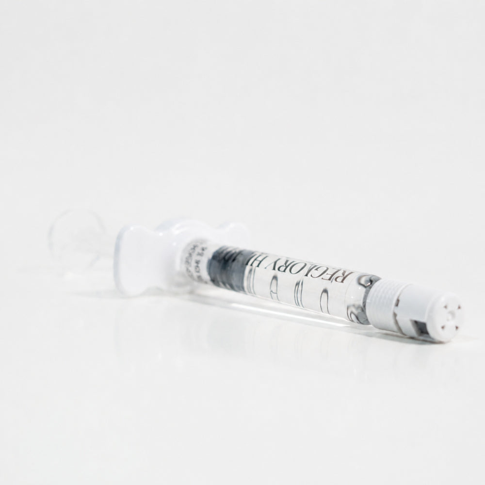 Close-up of Reglory HL 40+ Hyaluronic Acid Skin Booster syringe lying on white surface