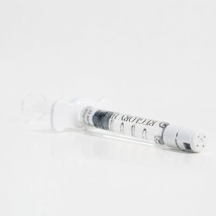 Close-up of Reglory HL 40+ Hyaluronic Acid Skin Booster syringe lying on white surface
