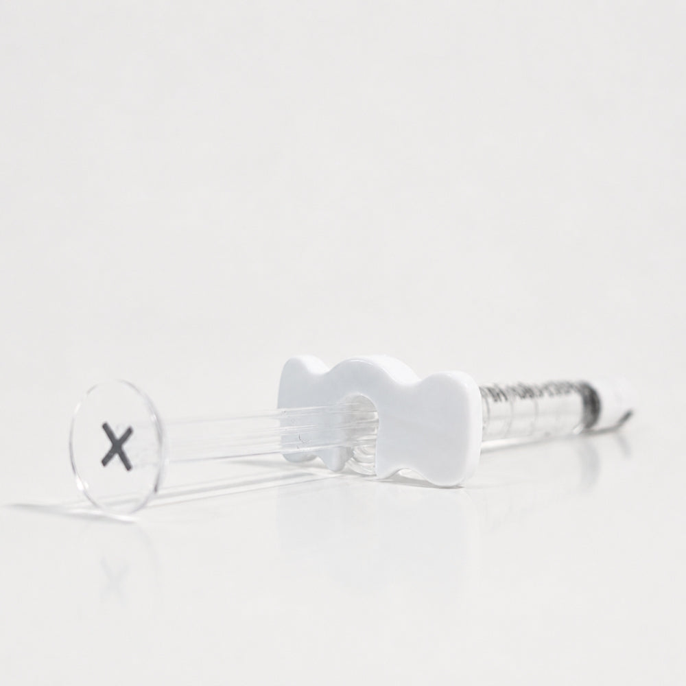 Reglory HL 40+ Hyaluronic Acid Skin Booster syringe lying on a white reflective surface