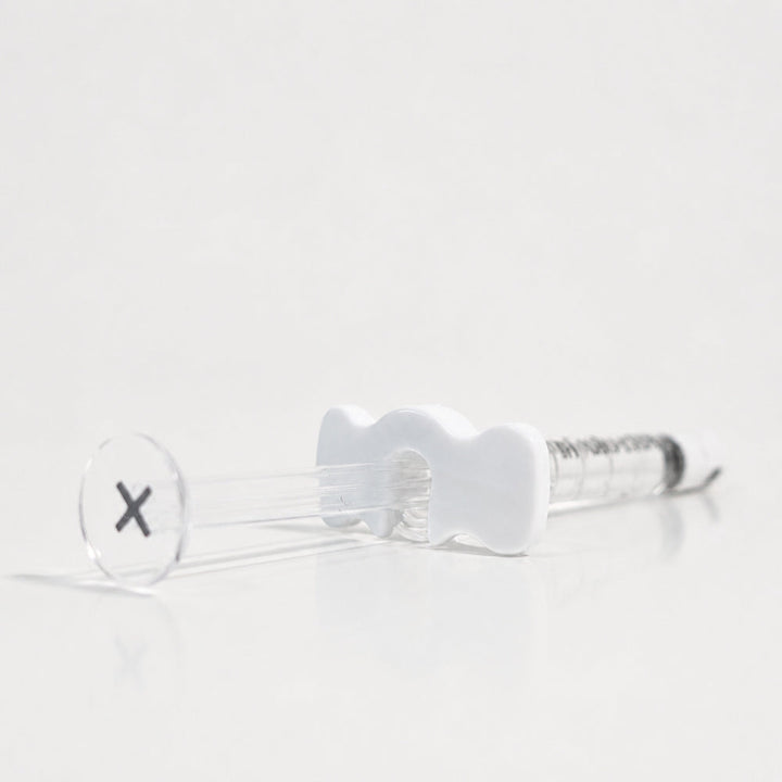 Reglory HL 40+ Hyaluronic Acid Skin Booster syringe lying on a white reflective surface