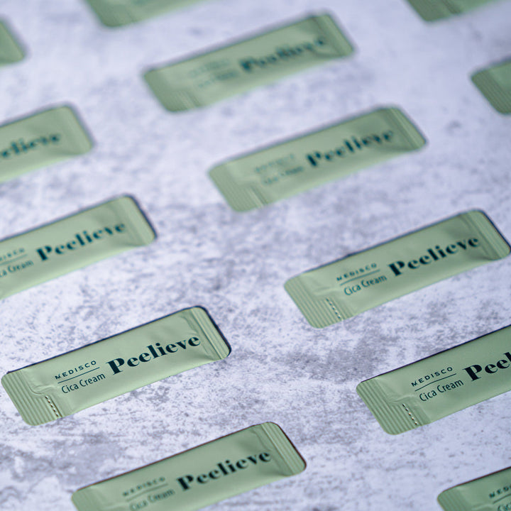 Multiple green sachets of Medisco Peelieve Cica Cream on a textured surface