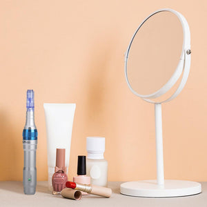 Image of Dr. Pen Ultima A6 Professional Plus device on table with mirror, lipstick, nail polish and beauty products